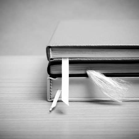 stack of book on wood background black and white color tone styleの写真素材