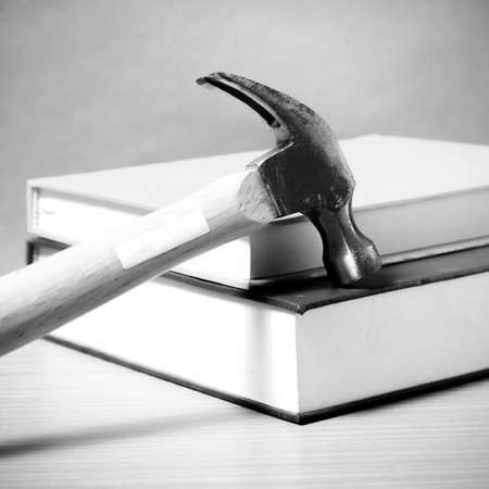 book with hammer on wood background black and white color tone styleの写真素材