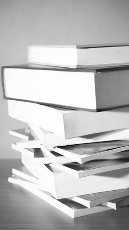 stack of book on wood table background black and white color tone styleの写真素材
