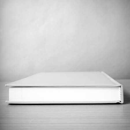 orange book on wood table background black and white color tone styleの写真素材