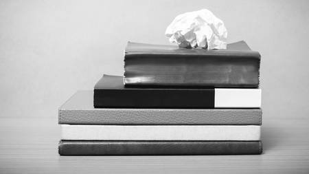 book and crumpled paper on wood background black and white color tone style