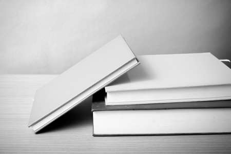 stack of book on wood table background black and white color tone style