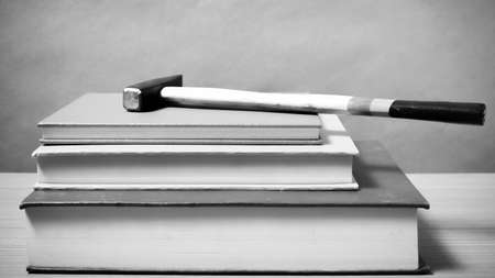 book with hammer on wood background black and white color tone styleの写真素材