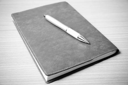 book and pen on wood background black and white color tone styleの写真素材