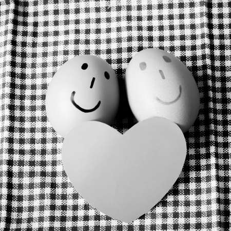 smile love egg couple in brown kitchen towel on wood table black and white color tone styleの写真素材