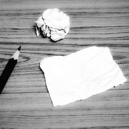paper scrap and crumpled with pencil on wood black and white color tone styleの写真素材