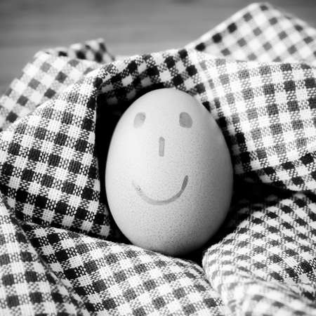 smile love egg couple in brown kitchen towel on wood table black and white color tone styleの写真素材