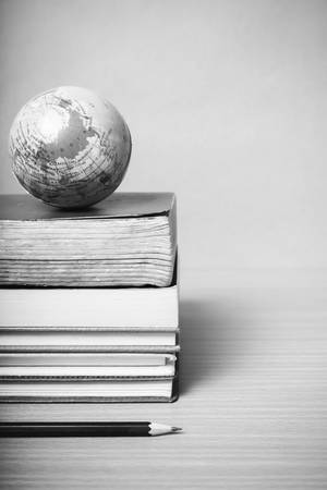 book and earth ball with black pencil on wood black and white color tone styleの写真素材