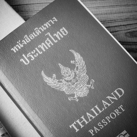 thai passport with notebook on wood table black and white color tone styleの写真素材