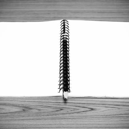 notebook and pencil on wood background black and white color tone styleの写真素材