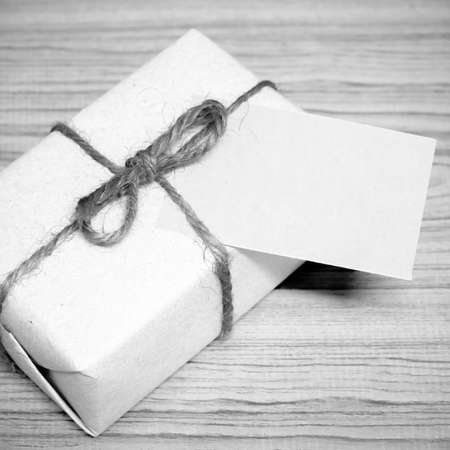 gift box and card on wood background black and white color tone styleの写真素材