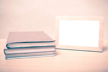 stack of book and photo frame on wood background vintage styleの写真素材