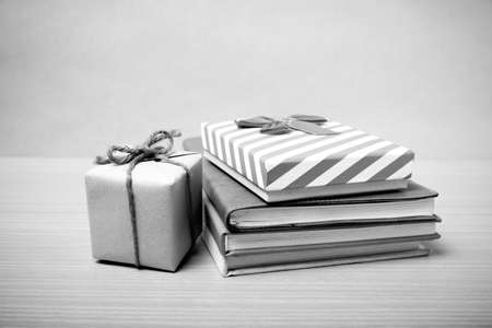 book with gift box on wood background black and white tone styleの写真素材