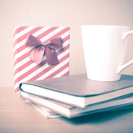 book with gift box and coffee mug on wood background vintage styleの写真素材