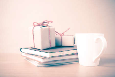 book with gift box and coffee mug on wood background vintage styleの写真素材