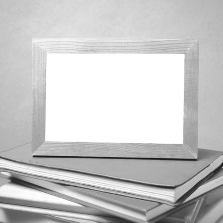 stack of book and photo frame on wood background black and white tone styleの写真素材