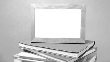 stack of book and photo frame on wood background black and white tone styleの写真素材