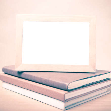 stack of book and photo frame on wood background vintage styleの写真素材