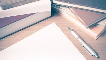 empty paper and pen with book on wood background vintage styleの写真素材