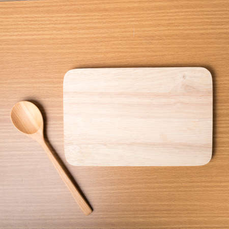 cutting board and wooden spoon on tableの写真素材