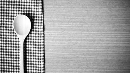 wood spoon and kitchen towel on table black and white color tone styleの写真素材