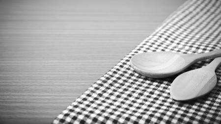 wood spoon and kitchen towel on table black and white color tone styleの写真素材