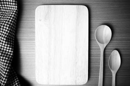 cutting board and wooden spoon on table black and white color tone styleの写真素材