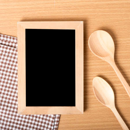 blackboard and wooden spoon on tableの写真素材