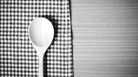 wood spoon and kitchen towel on table black and white color tone styleの写真素材