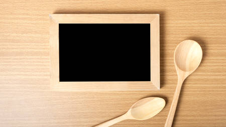blackboard and wooden spoon on tableの写真素材
