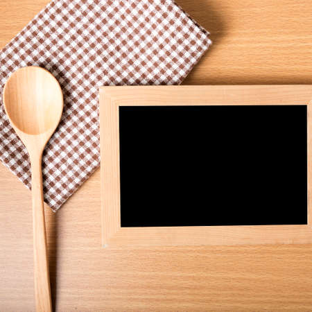 blackboard and wooden spoon on tableの写真素材