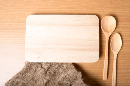 cutting board and wooden spoon on tableの写真素材