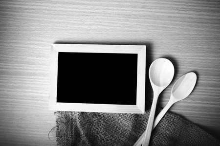 blackboard and wooden spoon on table black and white color tone styleの写真素材