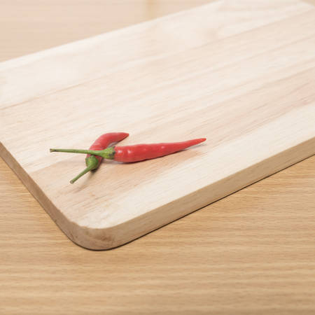 red chili peppers on cutting board over wood table backgroundの写真素材