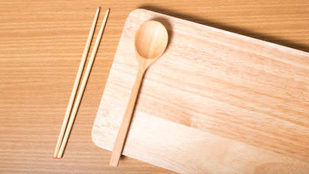 wood spoon with cutting board on table backgroundの写真素材