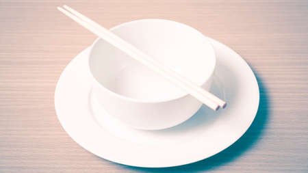 empty bowl with chopstick on wood table background vintage styleの写真素材