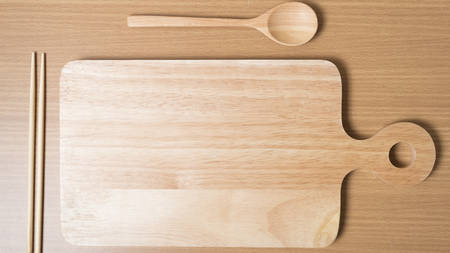 wood spoon with cutting board on table backgroundの写真素材