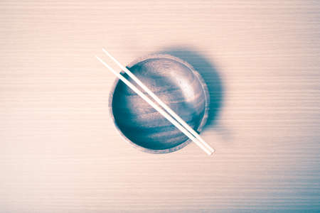 empty bowl with chopstick on wood table background vintage styleの写真素材