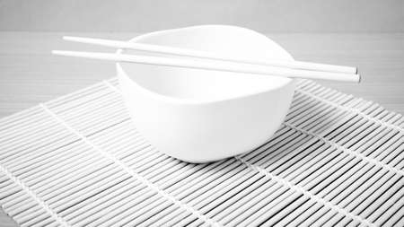 empty bowl with chopstick on wood table background black and white color tone styleの写真素材