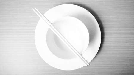 empty bowl with chopstick on wood table background black and white color tone styleの写真素材