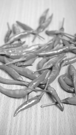 red chili peppers on wood table background black and white tone color styleの写真素材