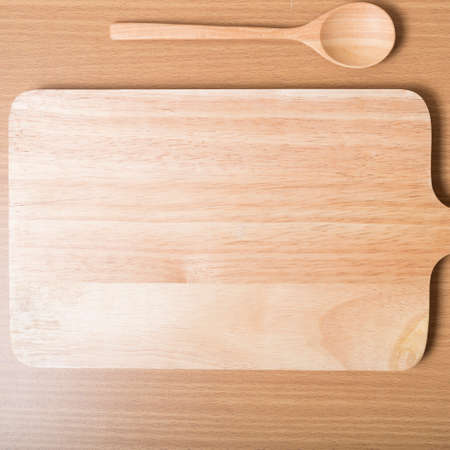 wood spoon with cutting board on table backgroundの写真素材
