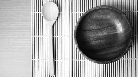 wood spoon bowl and chopstick on mat black and white color tone styleの写真素材