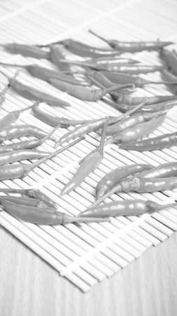 red chili peppers on wood table background black and white tone color style