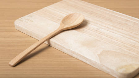 wood spoon with cutting board on table backgroundの写真素材