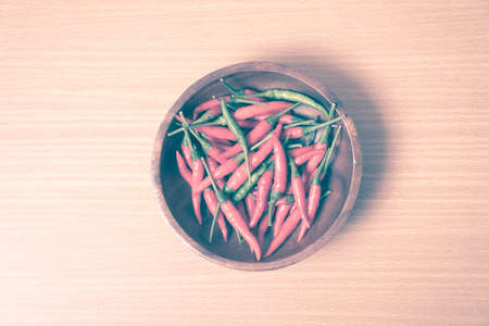 red chili peppers on wood table background vintage styleの写真素材