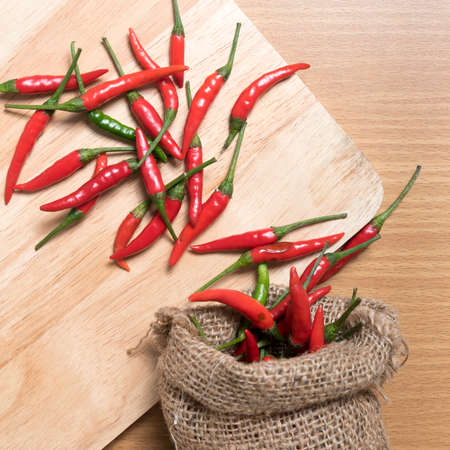 red chili peppers on cutting board over wood table backgroundの写真素材