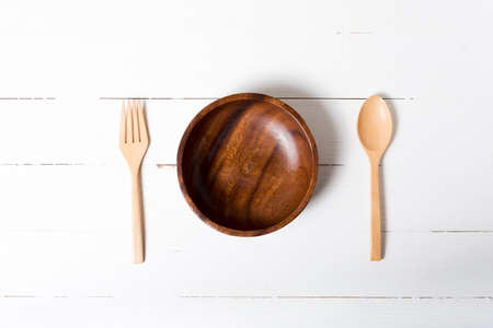 wood spoon and fork with bowl on white table backgroundの写真素材