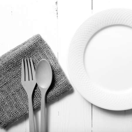 wood spoon and fork with dish over table background black and white tone color styleの写真素材