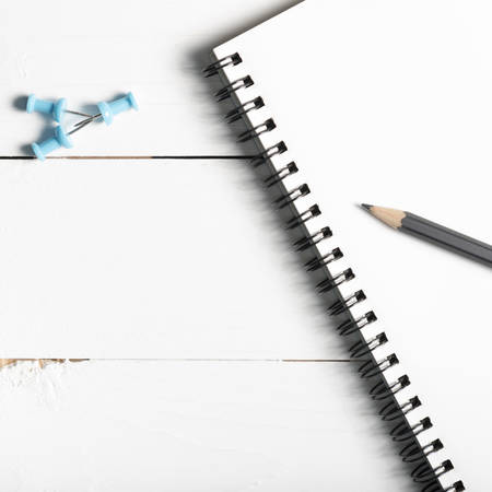 pencil and notepad with push pin over white table view from aboveの写真素材